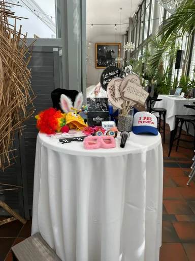 Tisch mit lustigen Requisiten wie Hüten und Brillen für die Fotobox.
