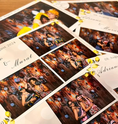 Fotoausdrucke mit Gästen, die vor der Fotobox bei einer Hochzeit in Fürstenfeldbruck posieren.