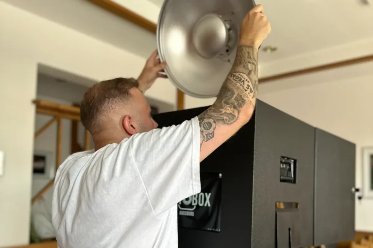 Mitarbeiter stellt die Fotobox ein und bereitet sie für den Einsatz auf einer Veranstaltung vor.
