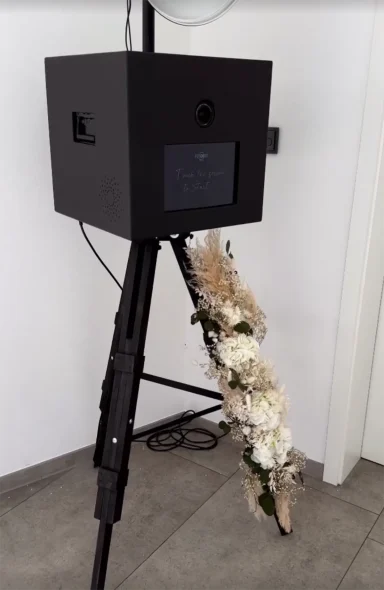 Fotobox mit Blumendekoration an den Beinen bei einer Hochzeit in Augsburg.